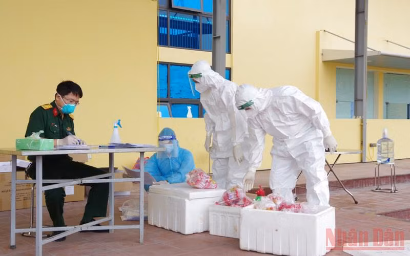 Đoàn công tác của quân đội tiếp nhận mẫu xét nghiệm sàng lọc SARS-CoV-2 tại nơi xét nghiệm lưu động.