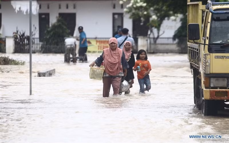 Người dân Luwu Utara, Indonesia mang theo đồ đạc đến nơi tạm trú. (Ảnh: Tân Hoa xã)
