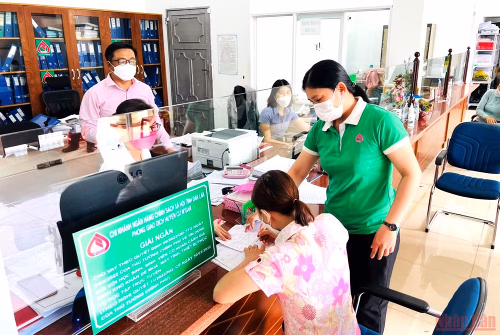 Cán bộ Phòng giao dịch Ngân hàng Chính sách-xã hội huyện Cư M’gar hướng dẫn người lao động làm thủ tục vay vốn ưu đãi theo Nghị quyết 11.