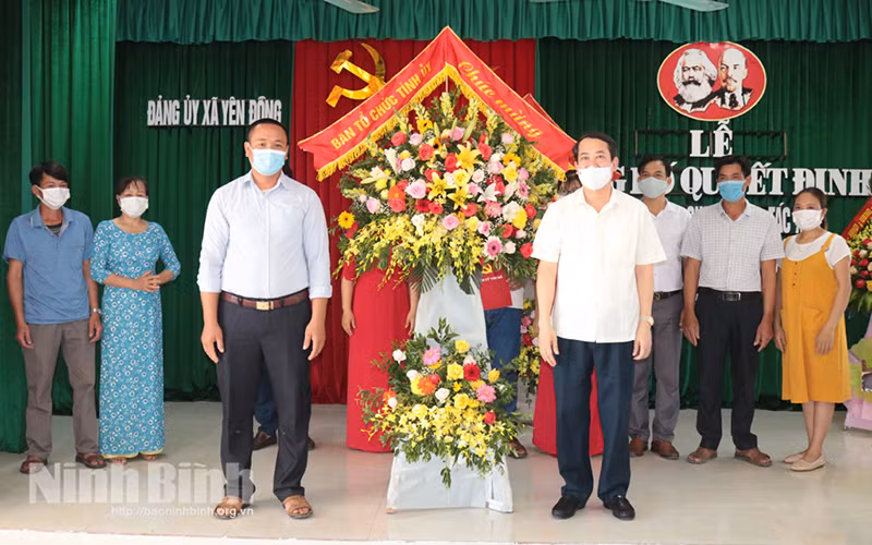 Đồng chí Mai Văn Tuất, Trưởng Ban Tổ chức Tỉnh ủy tặng hoa chúc mừng thành lập Chi bộ HTX chăn nuôi thủy sản Sông Đằng tháng 6/2021 (xã Yên Đồng, huyện Yên Mô). Ảnh: Thái Học