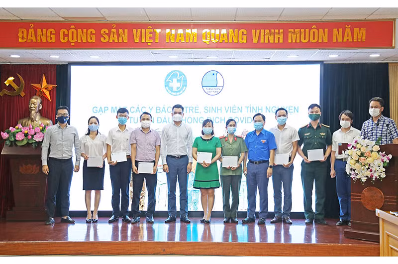 Các đồng chí Nguyễn Anh Tuấn (thứ năm, từ phải qua trong ảnh) và Hà Anh Đức (thứ năm, từ trái qua trong ảnh) trao các suất quà tặng một số y, bác sĩ trẻ, sinh viên tình nguyện ngành y tiêu biểu trên tuyến đầu chống dịch.