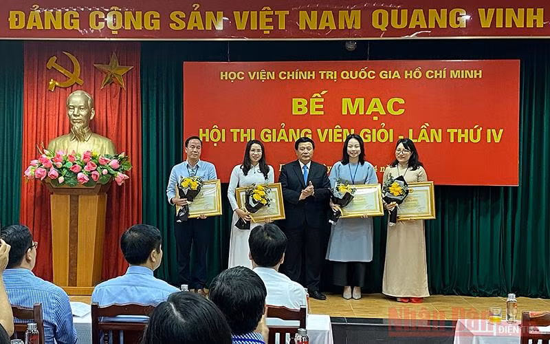 Đồng chí Nguyễn Xuân Thắng trao Bằng khen cho bốn giảng viên đạt danh hiệu Giảng viên xuất sắc. Ảnh: TRỊNH DŨNG