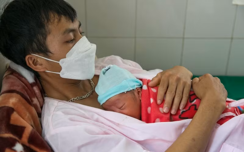 Anh Mùa A Nhìa, người dân tộc H'mông, 21 tuổi, thực hiện phương pháp da kề da với con trai sinh non tại phòng Kangaroo, Bệnh viện đa khoa tỉnh Điện Biên.