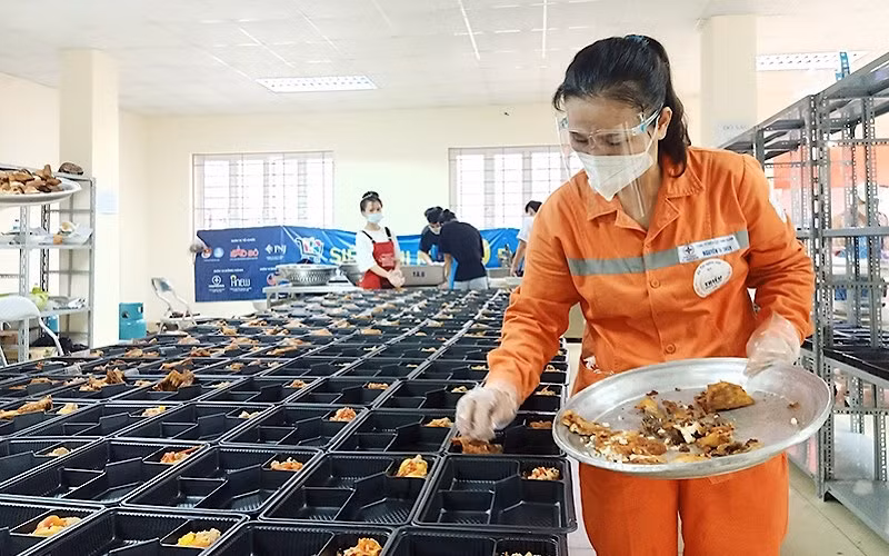 Những người thợ điện trong đồng phục màu cam đặc trưng chuẩn bị các suất ăn gửi tặng đồng bào có hoàn cảnh khó khăn.
