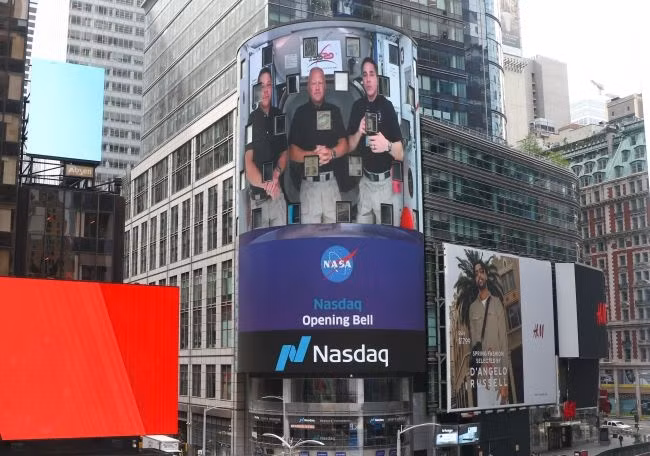 Các phi hành gia của NASA (từ trái sang) Robert Behnken, Douglas Hurley và Chris Cassidy xuất hiện trên màn hình tivi lớn của Nasdaq trên Quảng trường Thời đại ở New York vào ngày 2-6. Ảnh: Nasdaq.