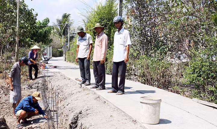 Ban giám sát đầu tư cộng đồng và người dân ấp Xóm Chùa, xã Tân Lân (Cần Ðước, Long An) giám sát công trình giao thông nông thôn.