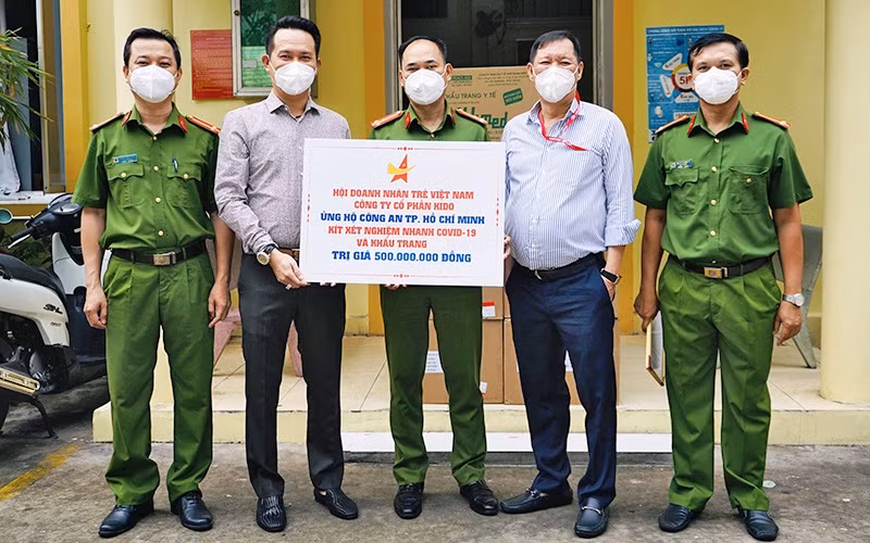 Chủ tịch Hội Doanh nhân trẻ Việt Nam Đặng Hồng Anh (thứ 2 từ trái sang) trao kít xét nghiệm và khẩu trang tặng các cán bộ, chiến sĩ công an TP Hồ Chí Minh.