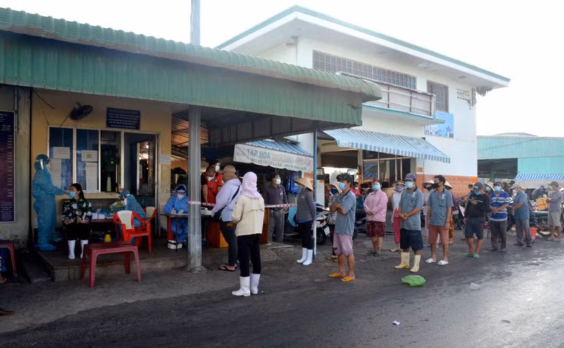 Người lao động tại khu vực Chợ cá Cồn Chà thuộc Cảng cá Phan Thiết (Bình Thuận) chờ lấy mẫu test nhanh SARS-CoV-2. 