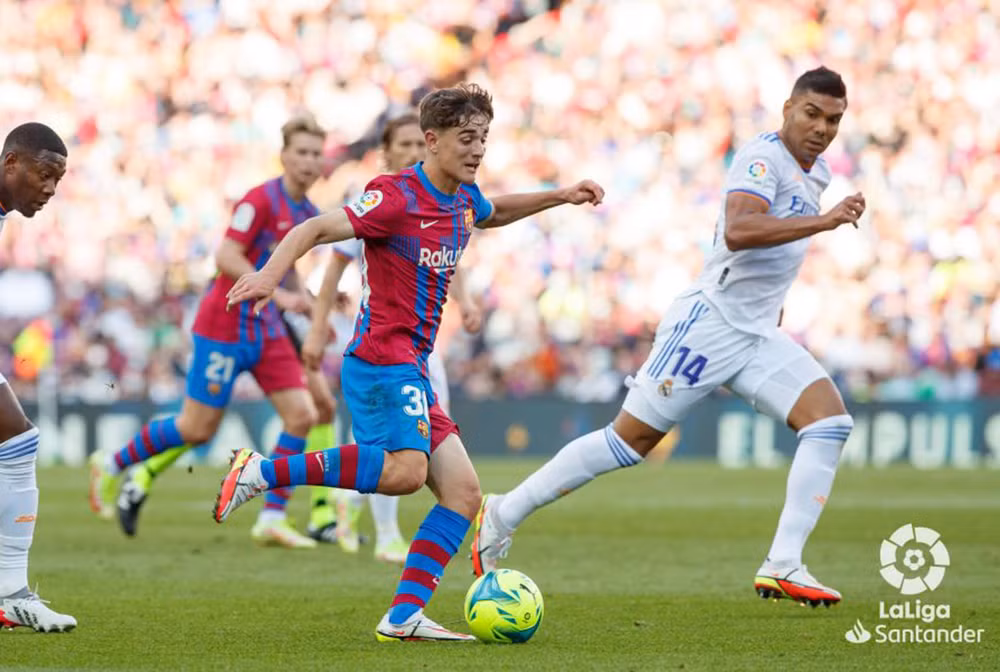 Gavi nỗ lực rê bóng trong vòng vây 2 cầu thủ Real Madrid. (Ảnh: LaLiga)
