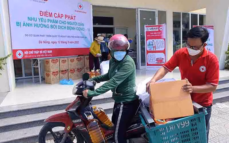 Hỗ trợ người dân mang nhu yếu phẩm về.