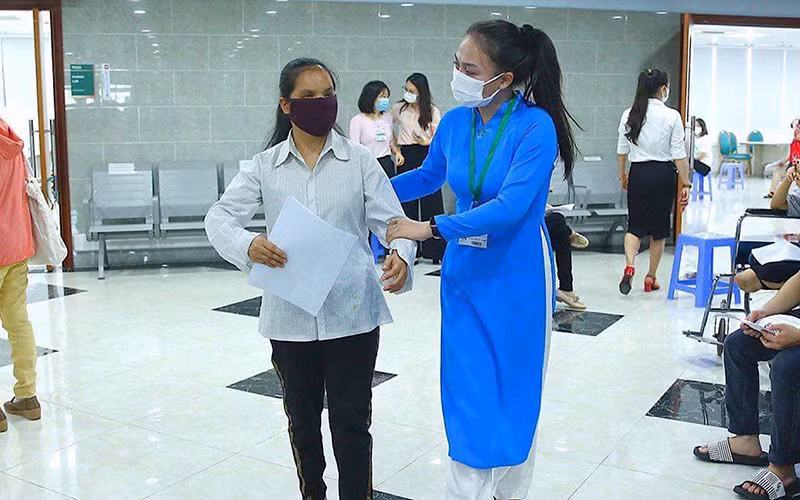 Nhân viên y tế hỗ trợ người khiếm thị tiêm ngày 29/7. (Ảnh: Bệnh viện Bạch Mai và Bộ KH&ĐT)