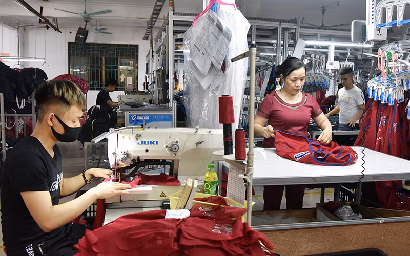 Công nhân Công ty cổ phần Nam Tiệp (Cụm công nghiệp An Xá, TP Nam Ðịnh, tỉnh Nam Ðịnh) may quần áo hàng xuất khẩu sang thị trường Nga, châu Âu, Mỹ. Ảnh: NAM ANH 