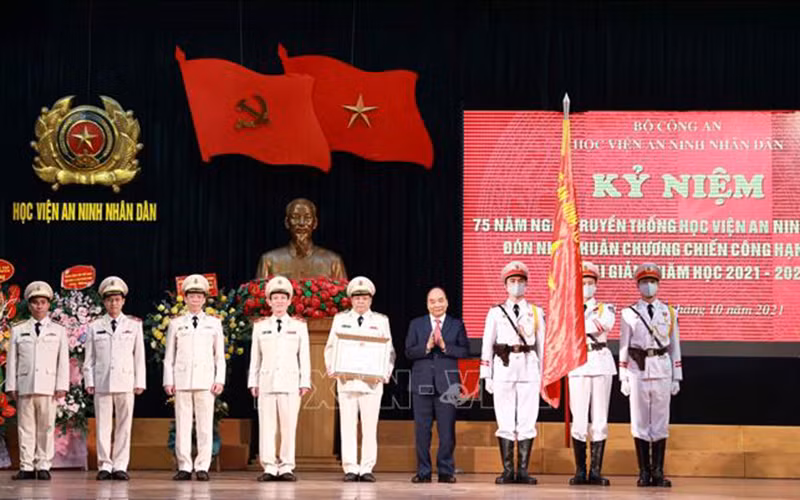 Chủ tịch nước Nguyễn Xuân Phúc trao tặng Huân chương Chiến công hạng Nhất cho Học viện An ninh nhân dân. (Ảnh: TTXVN)