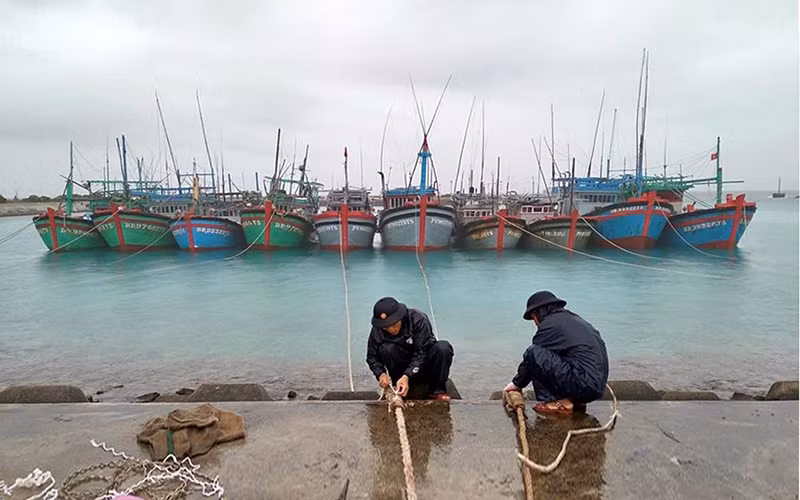 Cán bộ, nhân viên Trung tâm dịch vụ hậu cần - kỹ thuật đảo Sinh Tồn hỗ trợ ngư dân neo đậu tàu. Ảnh: ÐÌNH HOÀNG