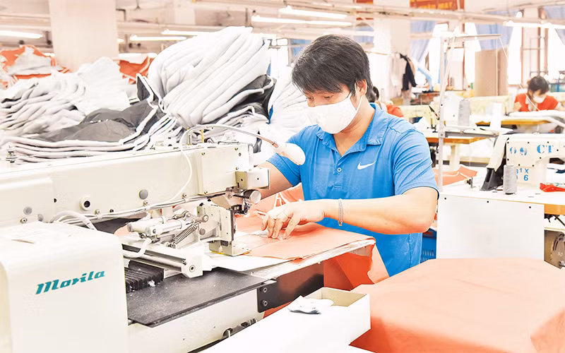 Công nhân Công ty May Chiến Thắng vận hành dây chuyền may áo xuất khẩu. (Ảnh AN KHÁNH) 