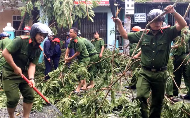 Công an tỉnh Thừa Thiên Huế cùng các đơn vị chức năng dọn dẹp cây xanh ngã đổ do bão số 5 gây ra trên địa bàn. Ảnh: CÔNG HẬU