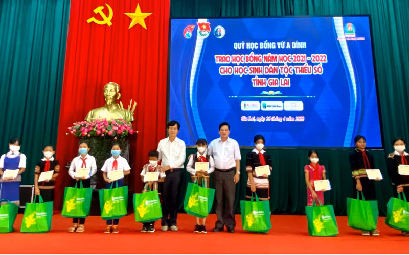 Ông Nguyễn Trân Châu, Phó Giám đốc Thường trực Quỹ “Học bổng Vừ A Dính”, Phó Tổng Biên tập Báo Thiếu niên Tiền phong và Nhi đồng trao học bỗng cho các em học sinh.