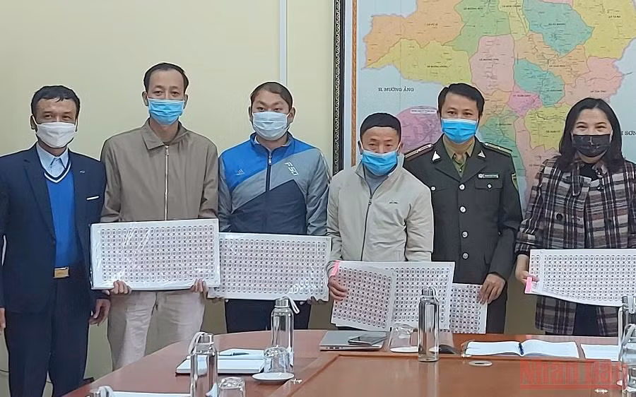 Cán bộ Chi cục tiêu chuẩn và đo lường chất lượng, Sở Khoa học-Công nghệ tỉnh Điện Biên, bàn giao tem truy xuất nguồn gốc cây đào cho huyện Tuần Giáo.