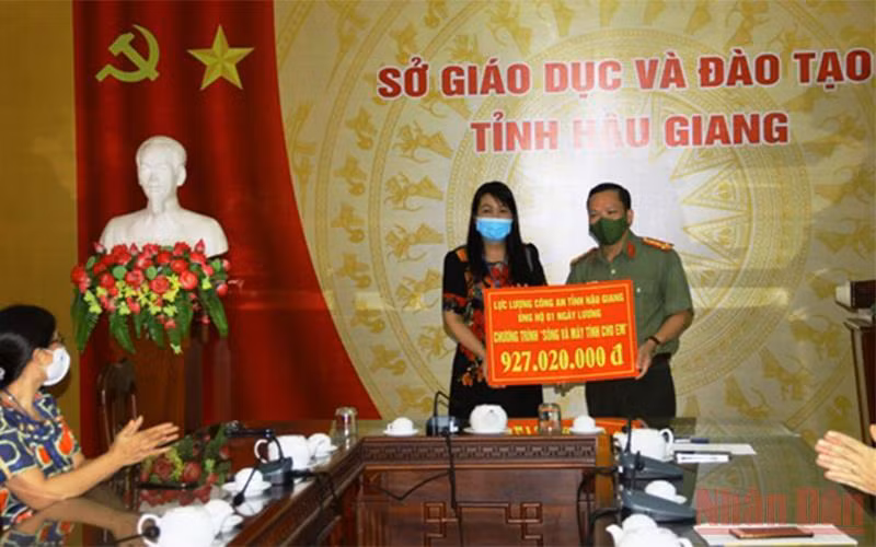 Lãnh đạo Công an tỉnh Hậu Giang trao bảng tượng trưng cho Sở Giáo dục và Đào tạo.