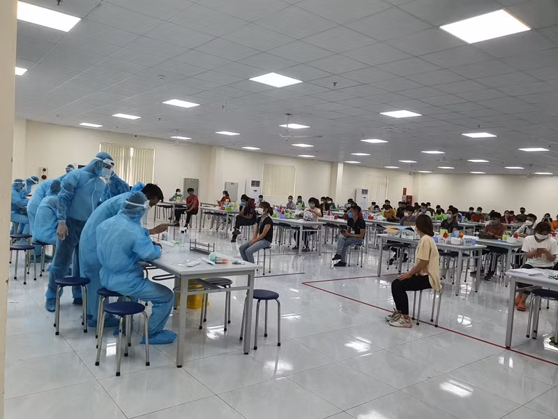 Lực lượng y tế lấy mẫu xét nghiệm Covid-19 cho công nhân tại KCN Vân Trung. (Ảnh: ĐẶNG GIANG)