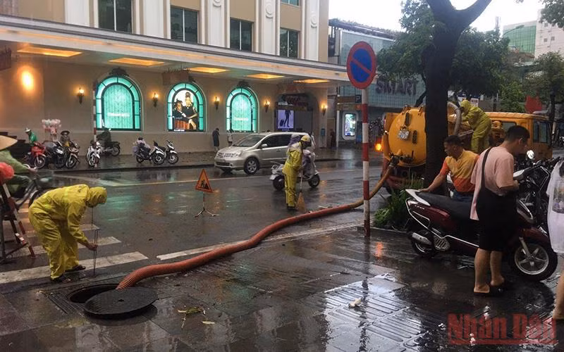 Công nhân Công ty Thoát nước Hà Nội khơi thông cống ngầm để tăng cường thoát nước trên phố Hai Bà Trưng, quận Hoàn Kiếm, Hà Nội.