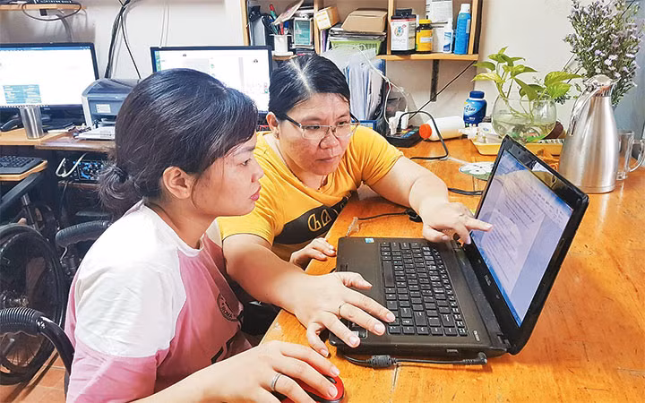 Chị Nguyễn Thị Mỹ Ngọc (áo vàng) bị liệt hai chân, là tấm gương làm kinh tế giỏi và giải quyết việc làm cho nhiều người khuyết tật.