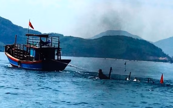 Lực lượng chức năng kéo phương tiện câu mực của ông Thà bị tàu cá đâm chìm trên biển vào bờ.