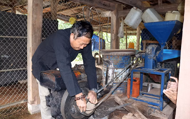 Ông Pờ Dần Sinh sửa máy xay xát thóc phục vụ người dân trong bản. 
