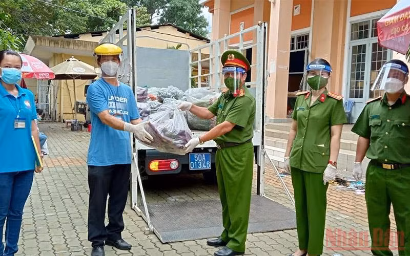 Đại diện Văn phòng Cơ quan Cảnh sát Điều tra Bộ Công an trao quà cho lãnh đạo UBND phường 27, quận Bình Thạnh (TP Hồ Chí Minh) sáng 15/8.