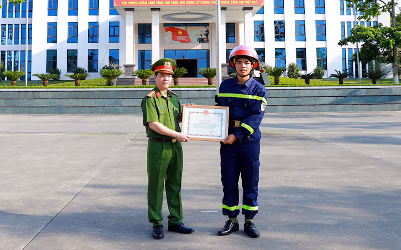 Đại tá Đỗ Tiến Thuỳ, Phó Giám đốc Công an tỉnh Tuyên Quang trao Bằng khen của Chủ tịch UBND tỉnh cho chiến sỹ Quan Ngọc Hoàng.