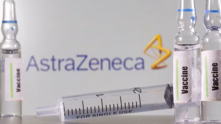 Một ống nghiệm dán nhãn vaccine được nhìn thấy phía trước logo AstraZeneca được chụp vào ngày 9-9-2020. Ảnh: Reuters.