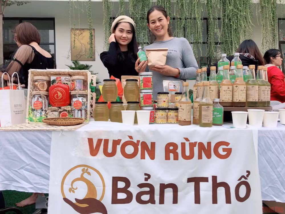 Ngọc Linh (bìa trái) giới thiệu sản phẩm của Vườn rừng Bản Thổ tại một phiên chợ nông nghiệp xanh.
