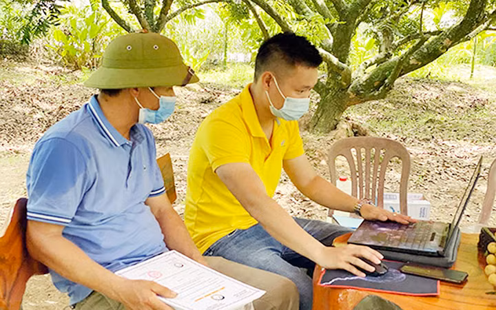 Nhân viên bưu điện hướng dẫn nông dân tỉnh Hưng Yên bán nhãn trên sàn thương mại điện tử. (Ảnh AN AN)