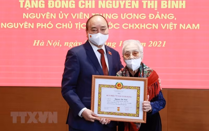 Chủ tịch nước Nguyễn Xuân Phúc trao tặng huy hiệu 75 năm tuổi Đảng cho bà Nguyễn Thị Bình, nguyên Phó Chủ tịch nước CHXHCN Việt Nam. (Ảnh: Thống Nhất/TTXVN)