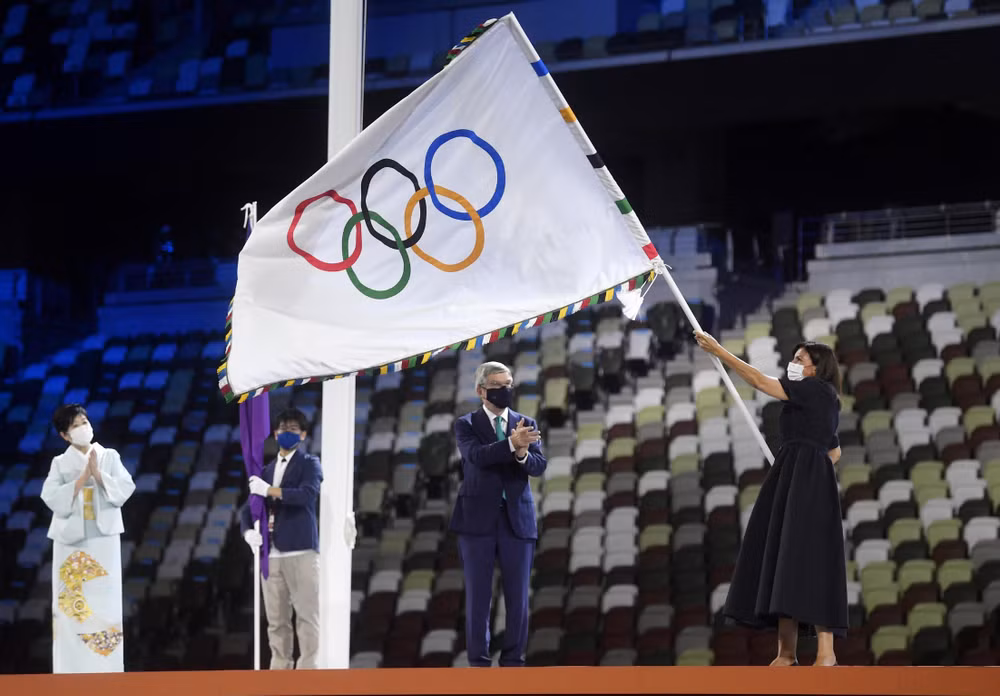 Lá cờ Olympic được trao cho đại diện của Paris trong lễ bế mạc Olympic Tokyo 2020. (Ảnh: Reuters)