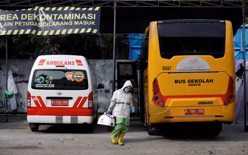 Trong bối cảnh dịch bệnh bùng phát tại Indonesia, hàng loạt tài xế ở Jakarta đã đăng ký sử dụng xe buýt để vận chuyển bệnh nhân Covid-19 tới bệnh viện, thay vì chở học sinh tới trường học. Ảnh: Reuters
