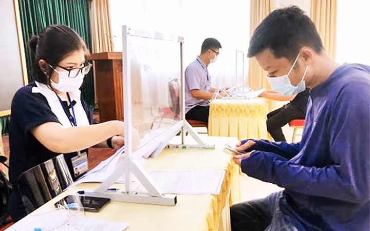 Người lao động ở quận Hoàn Kiếm nhận tiền từ gói hỗ trợ 26 nghìn tỷ đồng. (Ảnh: Thủy Trúc)