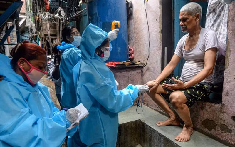 Nhân viên y tế đo thân nhiệt của người dân sống trong khu ổ chuột Dharavi, tại Mumbai. (Ảnh: Getty Images)