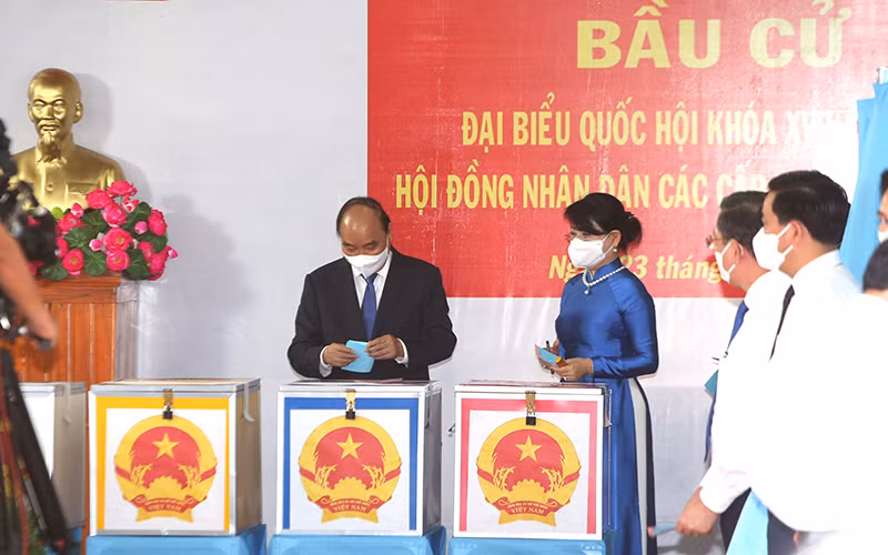 Chủ tịch nước Nguyễn Xuân Phúc cùng phu nhân bỏ phiếu tại khu vực bỏ phiếu số 041, đơn vị bầu cử số 9, thị trấn Củ Chi, huyện Củ Chi, TP Hồ Chí Minh.