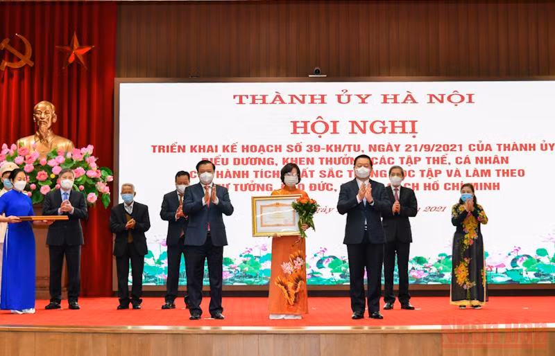 Bí thư Thành ủy Đinh Tiến Dũng và Trưởng Ban Tuyên giáo Trung ương Nguyễn Trọng Nghĩa trao bằng khen cho Ban Tuyên giáo Thành ủy Hà Nội. (Ảnh: Duy Linh) 