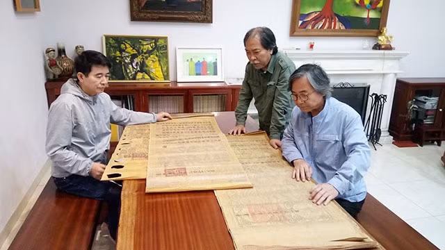 Từ trái qua: Ba thành viên nhóm Hà Đông - tác giả Trịnh Hữu Sỹ, nhà thơ Nguyễn Quang Thiều, đạo diễn Lương Tử Đức kiểm tra một số bản sắc phong.