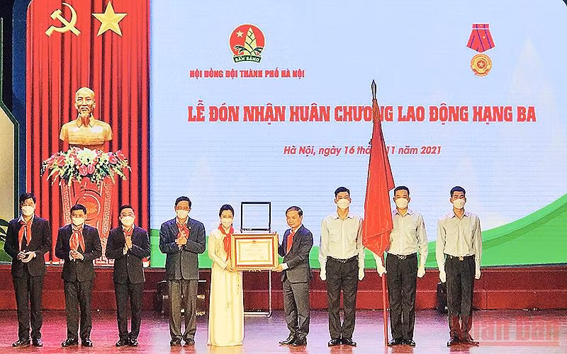 Đồng chí Phạm Tất Thắng (thứ tư từ bên phải sang trong ảnh) thừa ủy quyền của Chủ tịch nước, trao Huân chương Lao động hạng ba tặng Hội đồng Đội thành phố Hà Nội. 