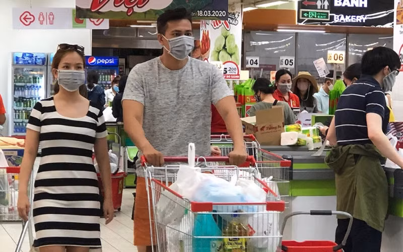 Người dân đeo khẩu trang khi đi mua sắm tại siêu thị vào tháng 3-2020. (Ảnh: T. Xuân)