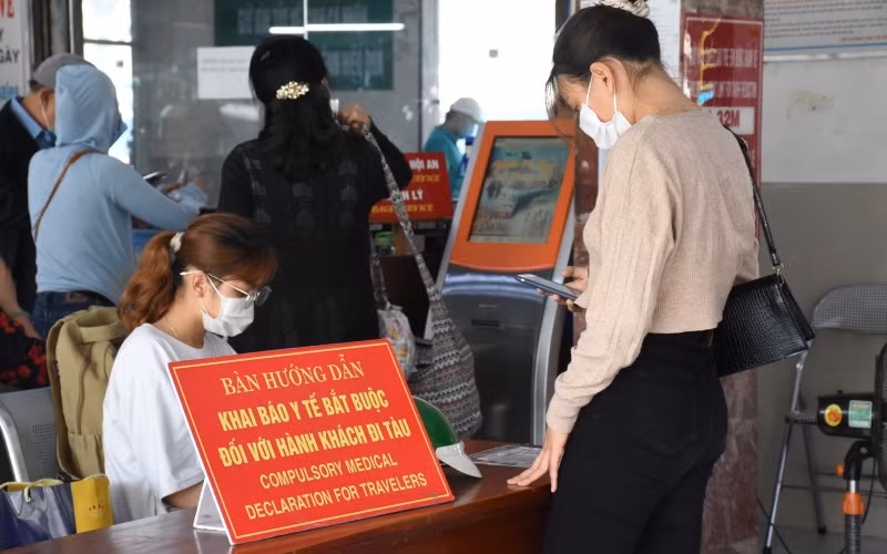 Nhân viên Ga Đà Nẵng hướng dẫn người dân khai báo y tế trước khi lên tàu.