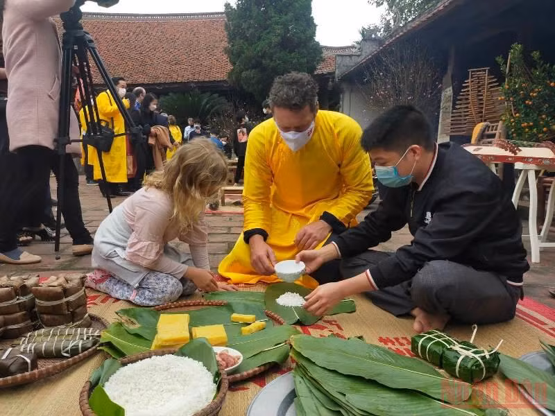 Khách quốc tế trải nghiệm gói bánh Chưng tại làng cổ Đường Lâm.