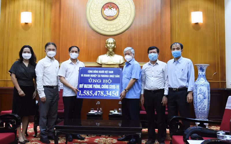 Bộ trưởng Ngoại giao Bùi Thanh Sơn trao tiền của cộng đồng người Việt và doanh nghiệp tại Fukuoka, Nhật Bản ủng hộ công tác phòng, chống dịch và Quỹ vaccine phòng Covid-19. (Ảnh: BNG)
