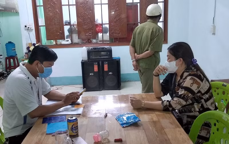 Lực lượng chức năng lập biên bản đối với chủ quán Huyền Cát Tuyền (nữ, bìa phải), tối 2-6.