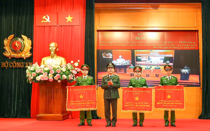 Thứ trưởng Công an Trần Quốc Tỏ thừa ủy quyền của Thủ tướng Chính phủ, tặng Cờ Thi đua xuất sắc của Chính phủ cho các học viện, trường Công an nhân dân tại Hội nghị Tổng kết công tác giáo dục, đào tạo năm 2021 và triển khai công tác giáo dục, đào tạo năm 2022 trong Công an nhân dân.