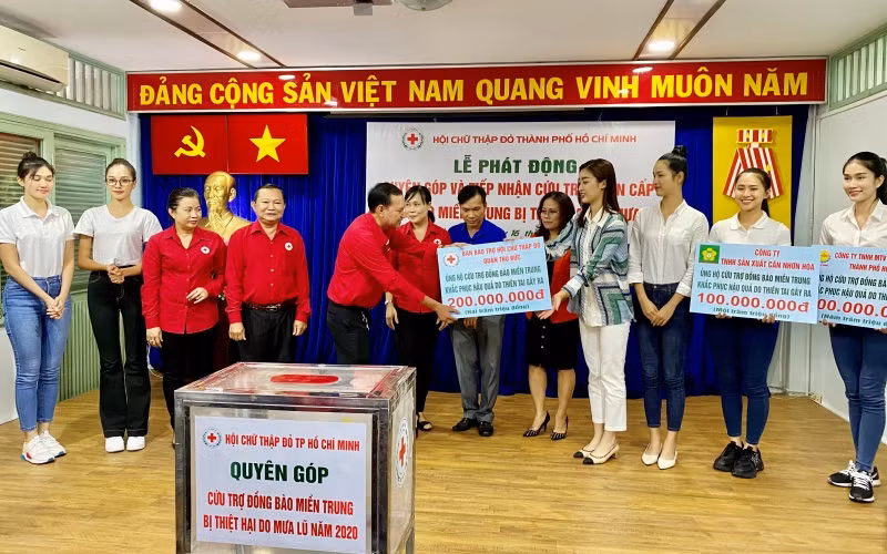 Các thí sinh tham dự Cuộc thi Hoa hậu Việt Nam là tình nguyện viên, cùng lãnh đạo Hội CTĐ TP Hồ Chí Minh tiếp nhận bảng biểu trưng đóng góp ủng hộ của các đơn vị.