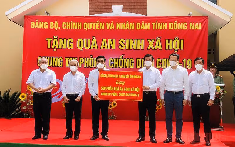 Bí thư Tỉnh ủy Đồng Nai Nguyễn Hồng Lĩnh trao bảng tượng trưng 500 phần quà cho lãnh đạo TP Long Khánh trao đến tận tay người có hoàn cảnh khó khăn.